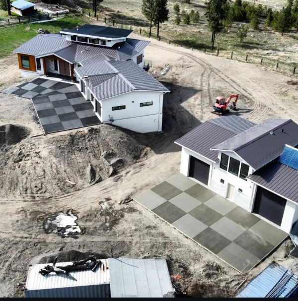 A modern house and garage with checkered concrete driveways under construction.