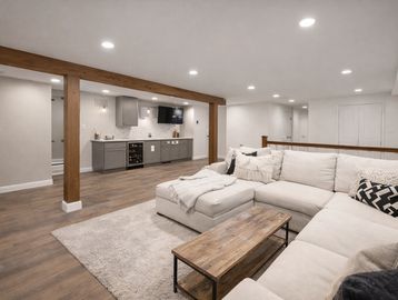 Modern basement with a cozy sectional sofa and kitchenette.
