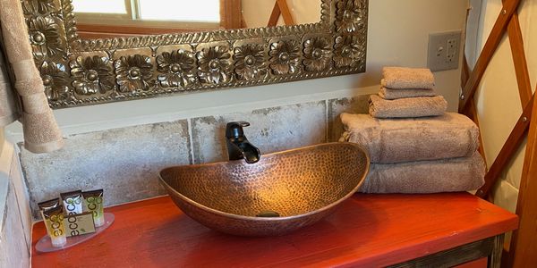 Custom bathroom vanity with copper sink and punched tin Mexican mirror in Cinnabar yurt