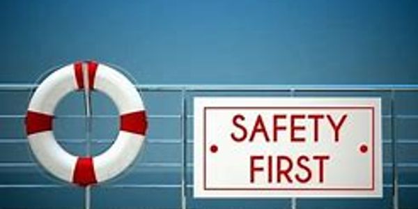 Life buoy and Safety First sign on a ship railing.