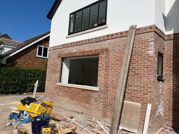 House under construction with building materials in foreground.