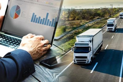 A person analyzing data on a laptop with trucks driving on a highway.