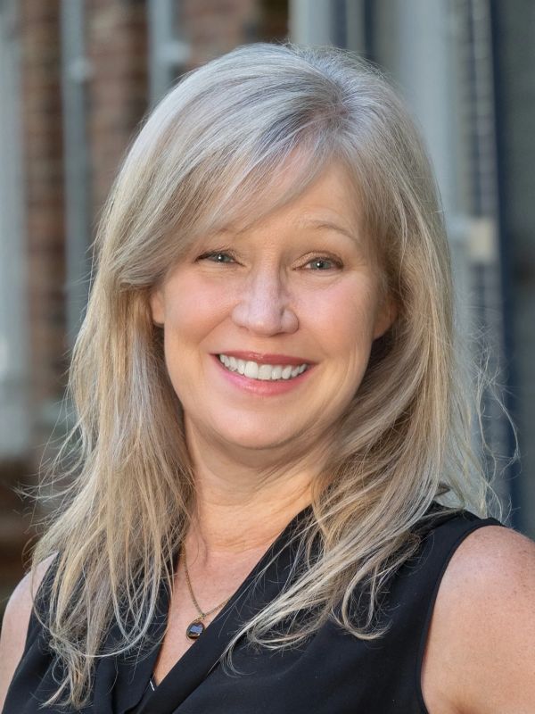 Smiling middle-aged woman with long blonde hair.