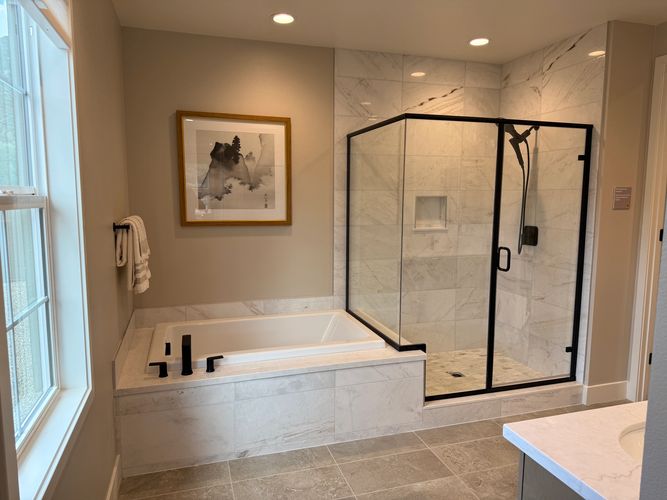 Beautiful Bathroom with soaking tub and walk in shower.  Black shower valve and faucet glass