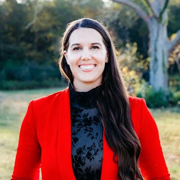 female counselor standing in front of a tree smiling 
