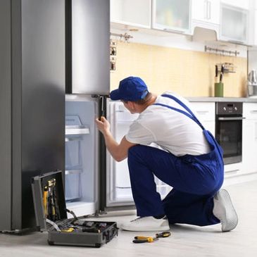 Appliance Repair Service Technician Repairing a Refrigerator. Refrigerator Repair in California. 