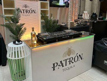 Patrón Tequila DJ booth setup with a bottle and plants.