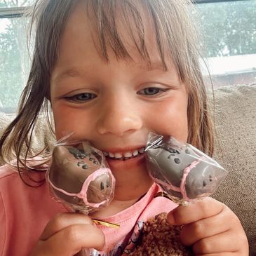 Child joyfully holding horse-shaped treats.