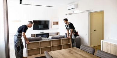 Couple of workers moving a box shelf.