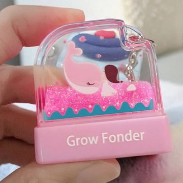 A pink whale and girl keychain with glitter inside.
