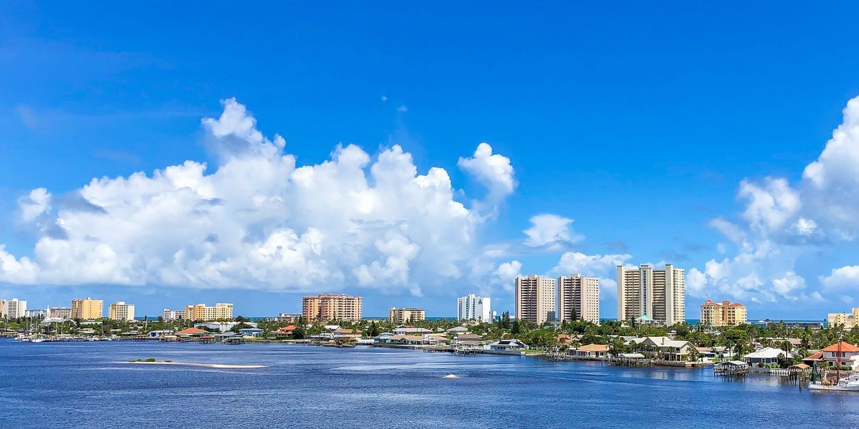 Coastal city skyline with buildings and blue sky.