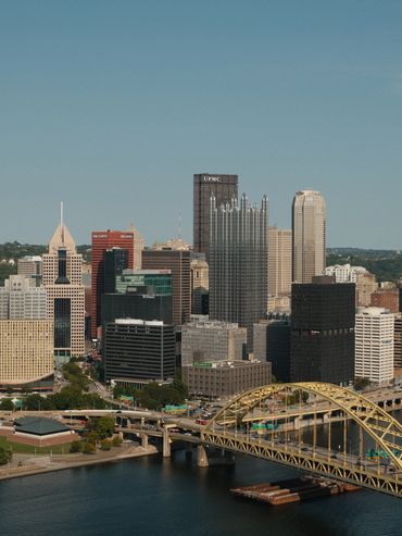 City skyline with bridges and river under a clear sky.
