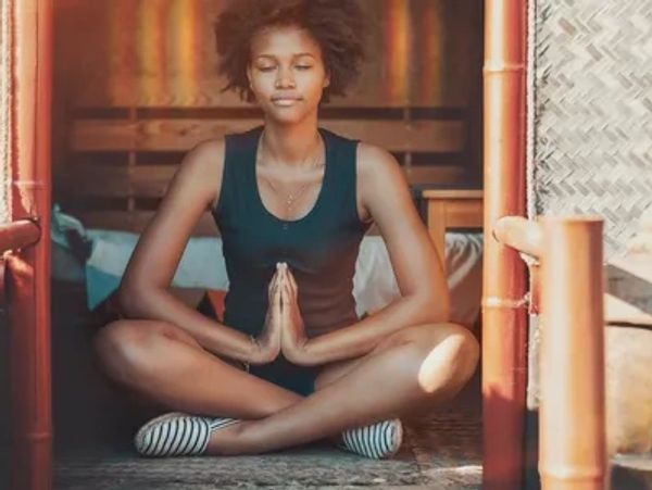 A female hands together sitting crossed legged meditating in a serene environment of calm manifest