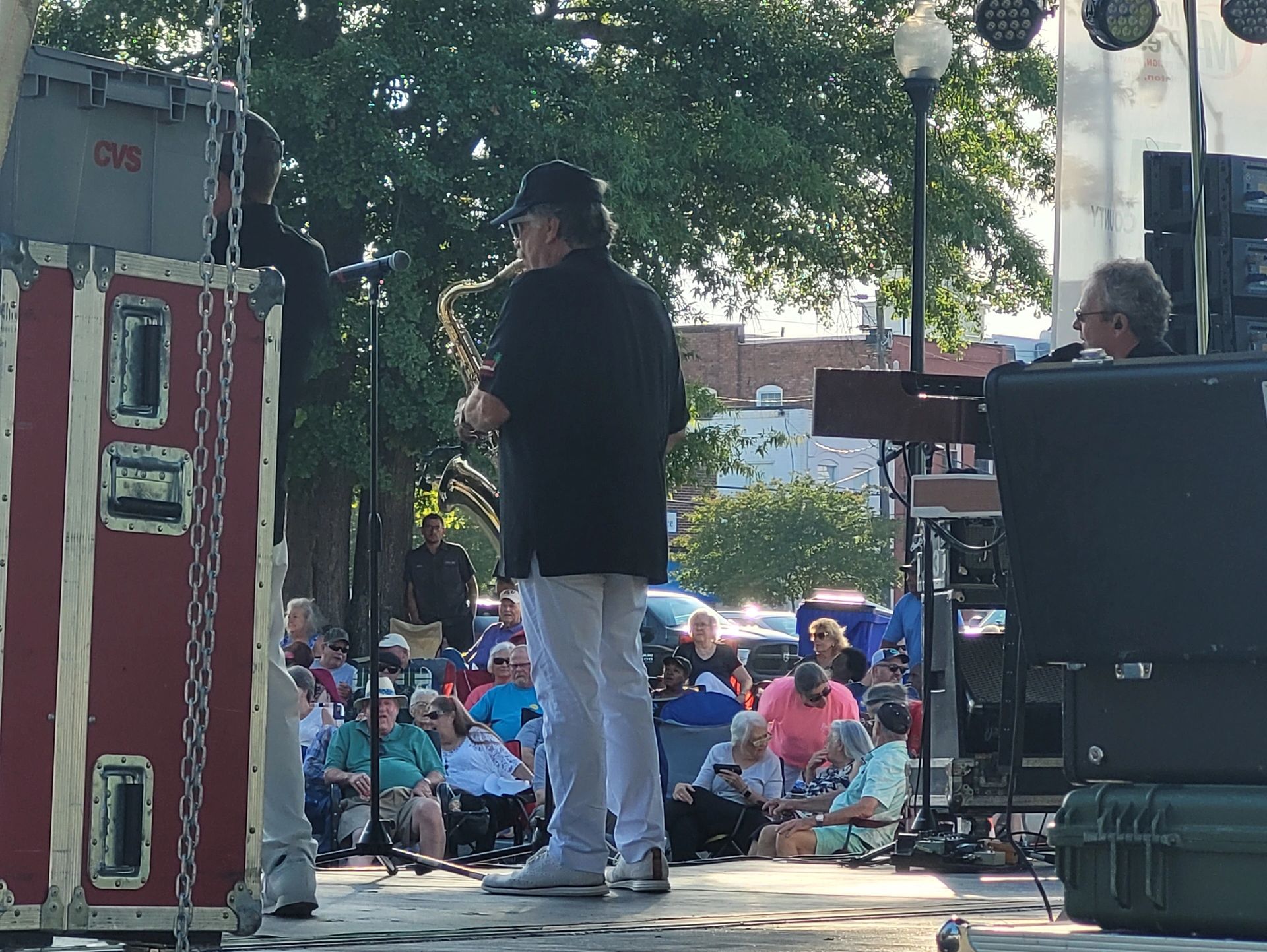 Man onstage playing saxophone in front of crowd