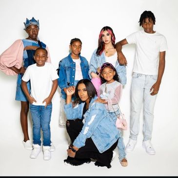 A diverse group of seven stylishly dressed young people posing against a white background.
