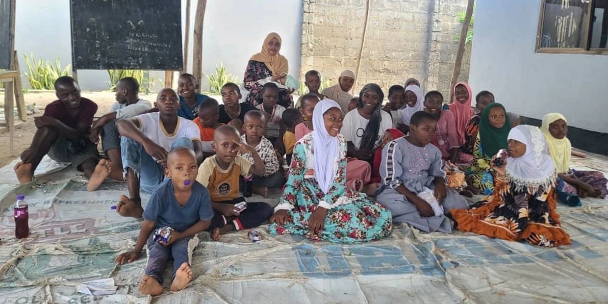 Group of children sitting together inside a room.