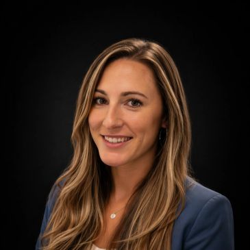 Professional portrait of a smiling woman with long hair against a dark background.