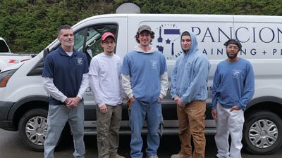 Five men standing in front of a company van.
