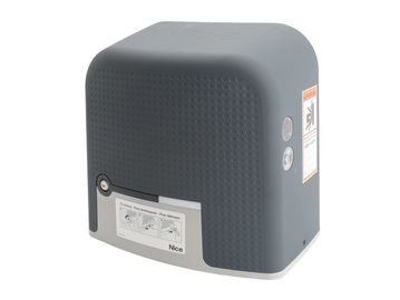 A gray and white motorized gate opener with a textured surface and warning label.