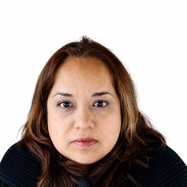Close-up portrait of a woman with brown hair and a neutral expression.