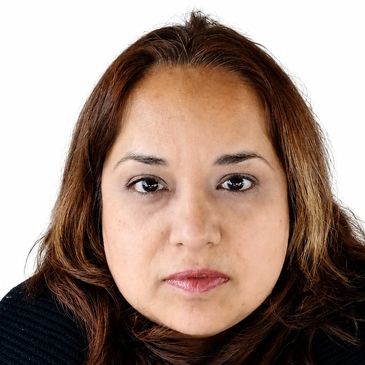 Close-up portrait of a woman with brown hair and a neutral expression.