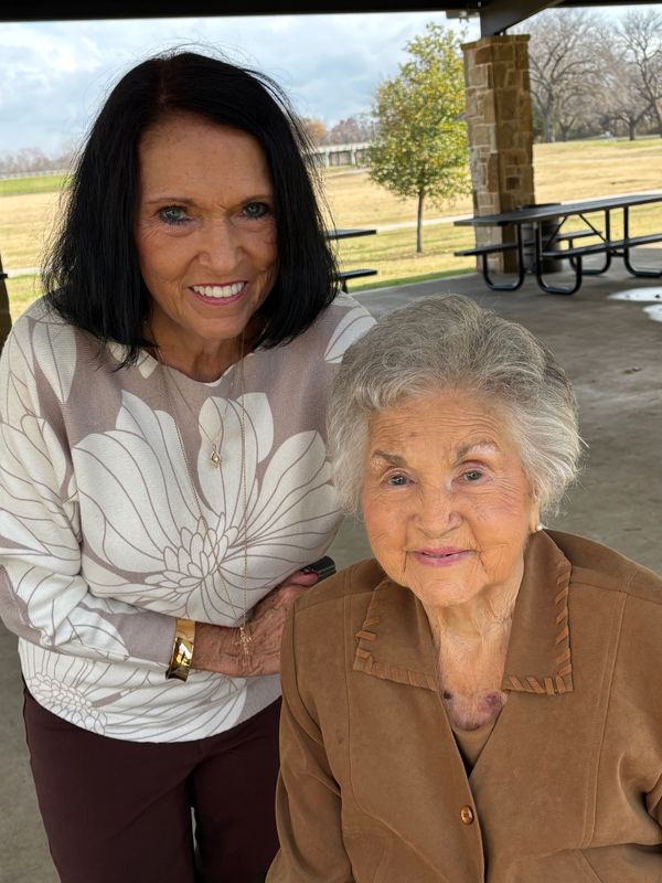 Two pain free women smiling together under a pavilion in a park. The purpose teachers of Abide Wellness. 