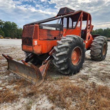 Orange heavy-duty forestry skidder with large tires.