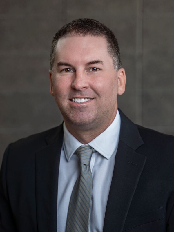 Professional headshot of a man in a suit and tie.