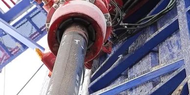 Close-up of industrial machinery with a large pipe and red clamp.