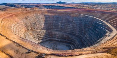 A large open-pit mine with terraced sides in a dry landscape.