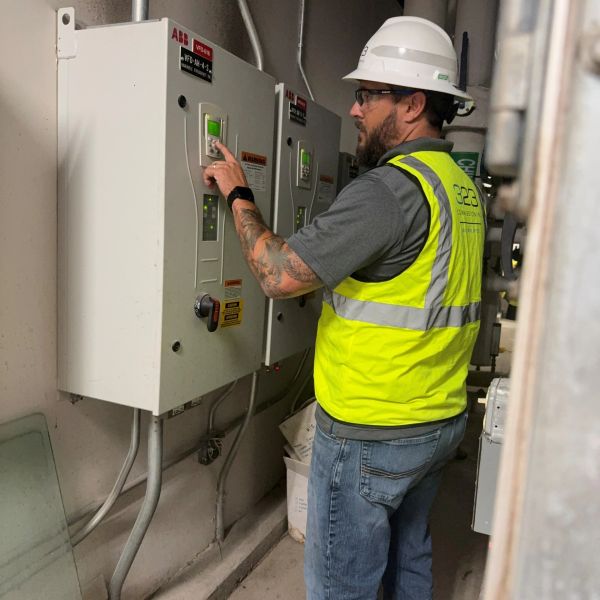Worker operating control panel in safety gear.