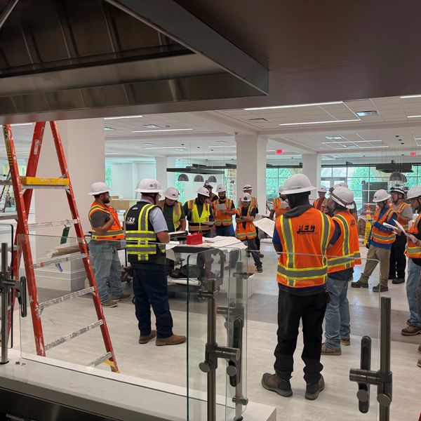 Group of construction workers in safety gear during meeting.