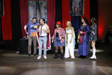 Group of people in costumes on stage during a performance.