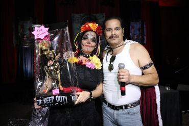Two people in costumes holding a trophy.
