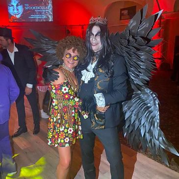 Two people in elaborate costumes at a party.