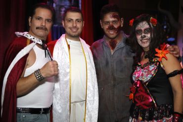 Four people in Halloween costumes posing for a photo.