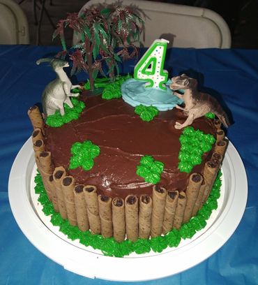 Custom chocolate cake decorated with a dinosaur theme. 