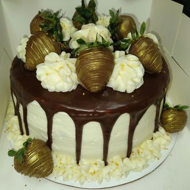 8inch cake frosted w American buttercream, topped w a chocolate drip & chocolate dipped strawberries