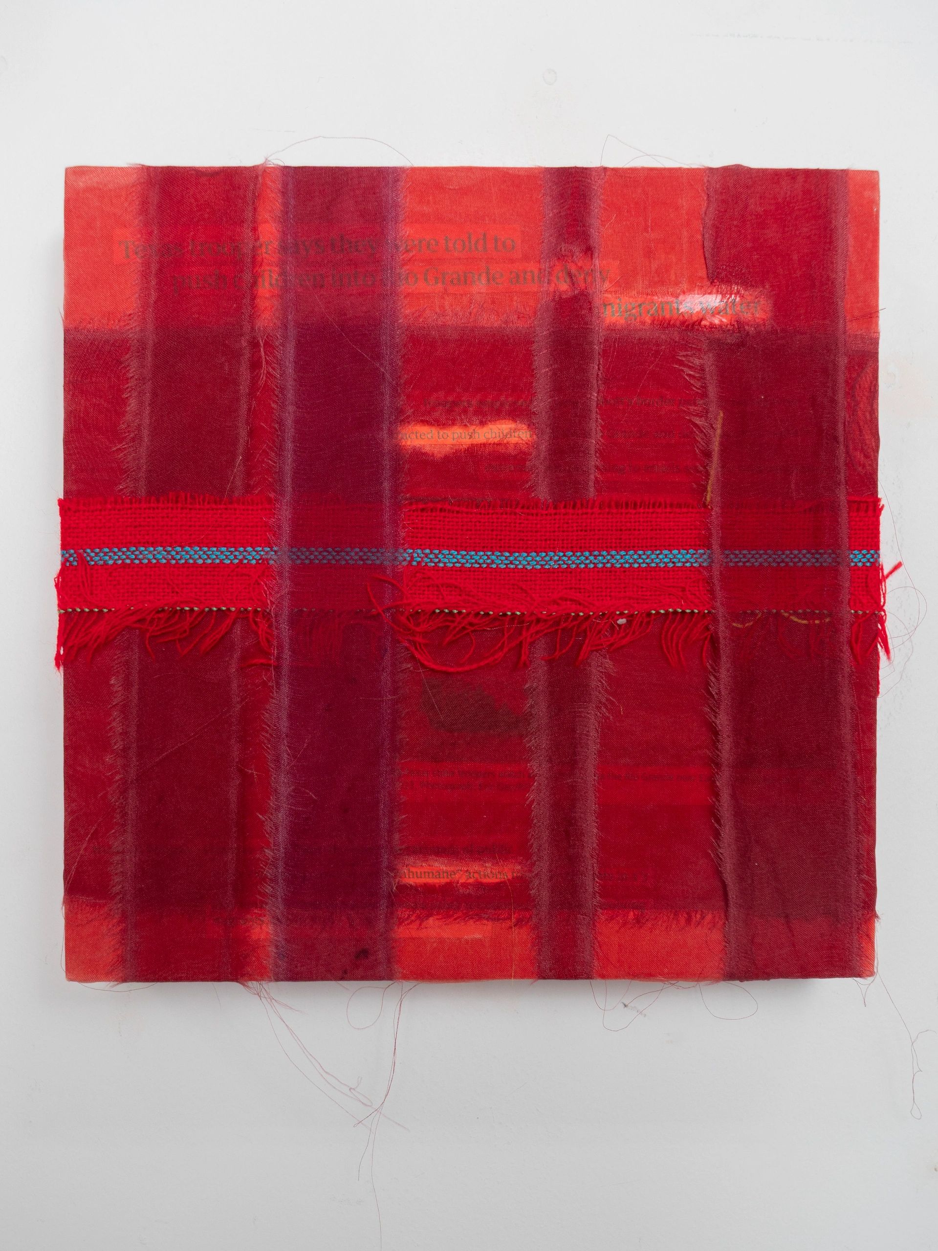 Fabric with red and orange woven ribbons stitched horizontally and vertically.