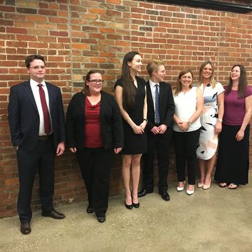 A group of lawyers stand against a brick wall at the BCBA annual meeting