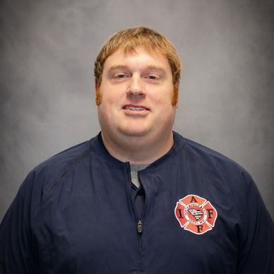 Portrait of a firefighter in uniform with an IAFF patch.