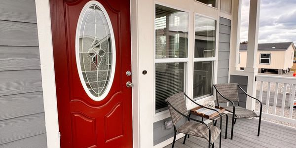 Interior of mobile home showing front porch seating and red door entrance