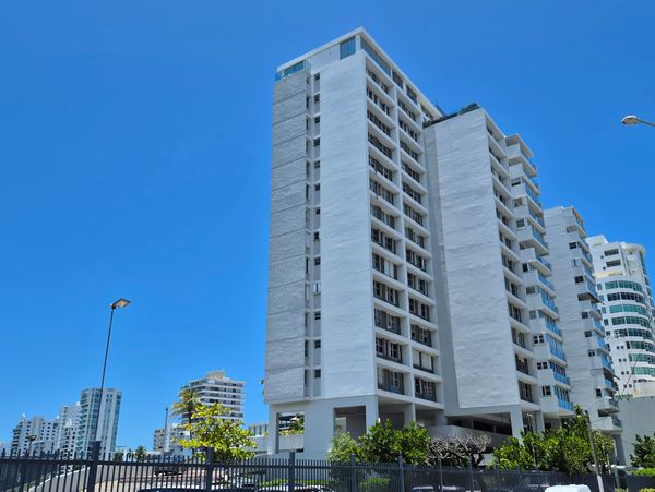 Modern white high-rise buildings under a clear blue sky.