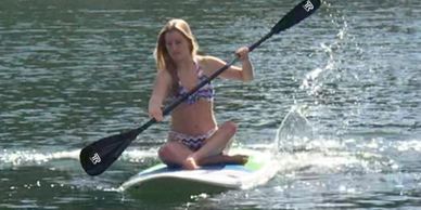 Young woman sitting on a paddle board