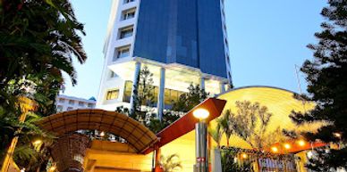 Modern high-rise building with glass facade at dusk.