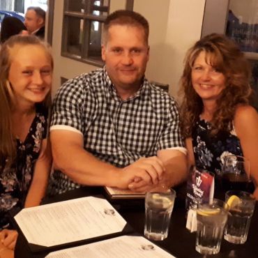 Family seated around a table with drinks and menus.