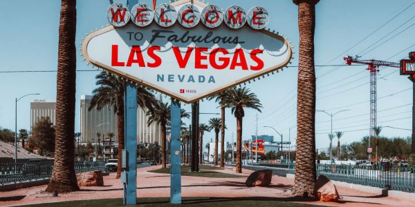 Famous Las Vegas welcome sign with palm trees and buildings.