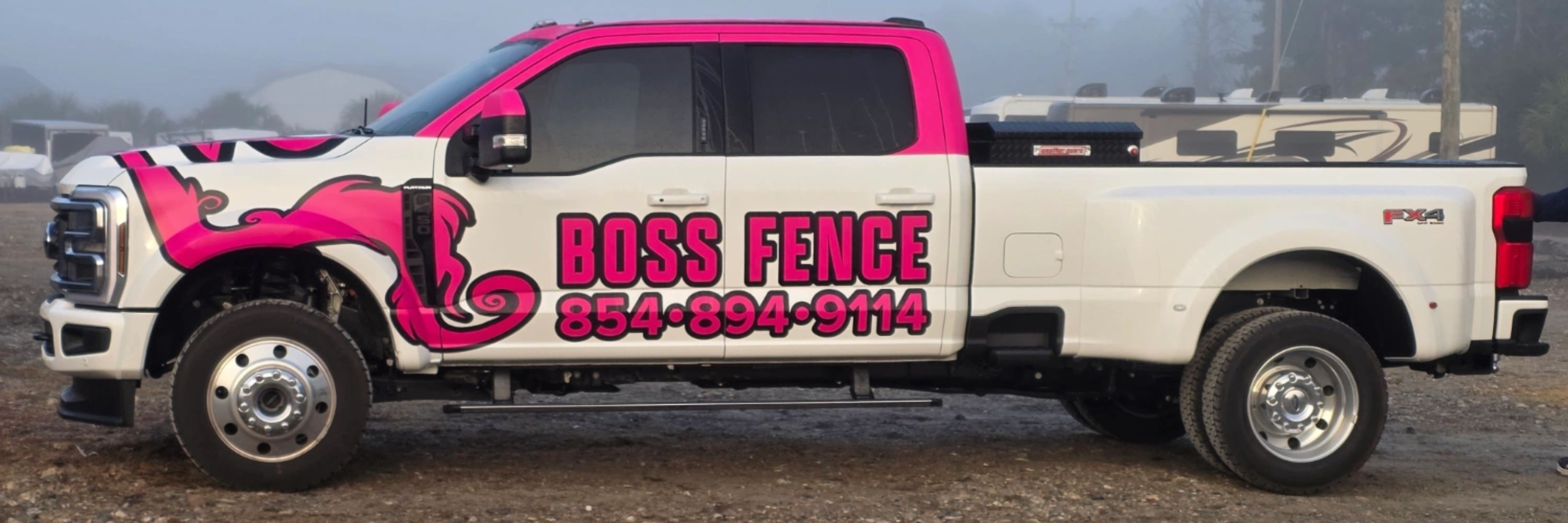 White and pink girl Boss Fence Ford F450 truck with contact number parked outdoors in Myrtle Beach, SC.
