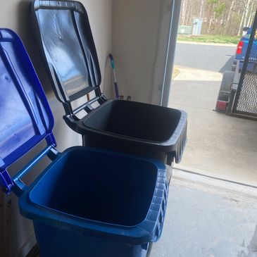 Two open trash bins in a garage near the door.