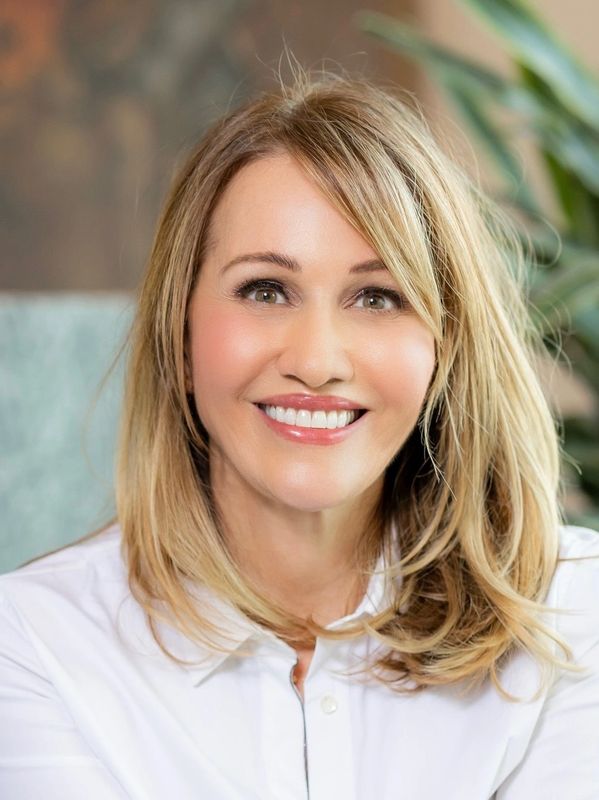 Confident woman in white shirt smiling.